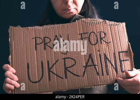 Frau hält ein Banner mit Anti-Kriegs-Botschaft. Protest gegen die russische Intervention in der Ukraine, Aktivismus und Menschenrechtsbewegung. Konzept der Standi Stockfoto