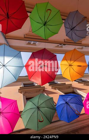 Farbenfrohe dekorative Regenschirme, die über der Piekarska-Straße in der Nähe des Stadtplatzes hängen, nach dem portugiesischen „Regenschirm-Himmel“-Design, Tarnow, Polen Stockfoto