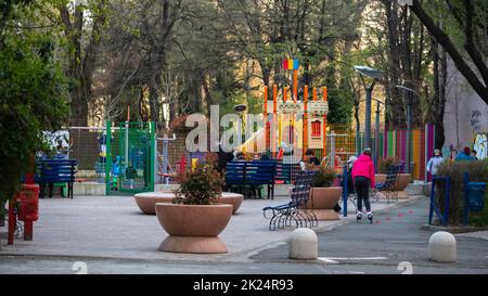 BUKAREST, RUMÄNIEN - 15. Mai 2021: Moderner Spielplatz mit weicher Oberfläche und einer großen Kinderrutsche. Aktiver Familienurlaub im Park. Kinder Schlittschuh Stockfoto