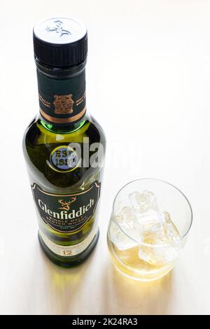 Moskau, Russland - 20. März 2022: Glas- und geschlossene Flasche des 12 Jahre alten Glenfiddich Single Malt Scotch Whisky auf dem Tisch. Die Glenfiddich Distillery wa Stockfoto