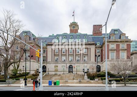 Staten Island Borough Hall mit Ampeln und Menschen, die die Straße im Vordergrund überqueren, New York City, während des Wintertages mit bewölktem, horizontales Licht Stockfoto