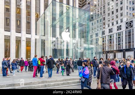 Eingang zum Apple Store Glass Cube, Manhattan, New York City mit vielen Menschen, die während des sonnigen Wintertages vor dem Hotel laufen, horizontal Stockfoto