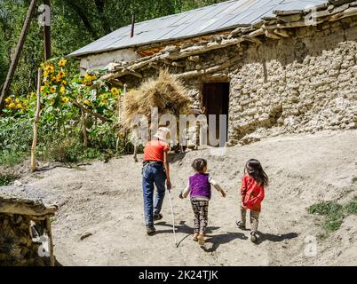 26. August 2016, Dorf Margib, Tadschikistan: Kinder folgen einem Esel in die Scheune eines kleinen Dorfes im Jaghnob-Tal in Tadschikistan Stockfoto