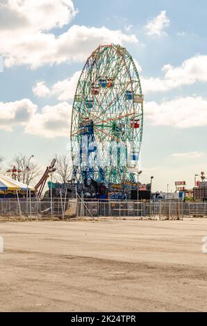 Wonder Wheel, Ferris Wheel im Luna Park Amusement Park, Coney Island, Brooklyn, Blick von der Seite, Strand und Zaun vor dem Hotel, New York City bei Sonne Stockfoto