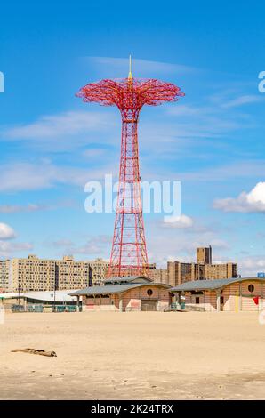 Red Parachute Jump im Luna Park Amusement Park, Coney Island, Brooklyn mit leerem Strand und Gebäuden vor dem Hotel an sonnigen Wintertagen mit bewölktem Himmel Stockfoto