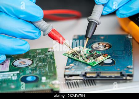 Techniker, der das Innere des Mobiltelefons mit einem Lötkolben repariert. Integrated Circuit. Das Konzept von Daten, Hardware, Technologie. Stockfoto
