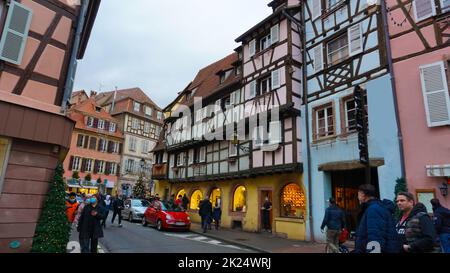 Colmar, Frankreich - 30. Dezember 2021: Menschen, die mit Weihnachtsschmuck auf die Straße gehen, in Colmar, im Elsass, Frankreich. Stockfoto