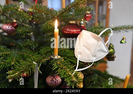 FFP2-Maske hängt auf einem Weihnachtsbaum, Österreich, Europa - FFP2 Maske hängt an einem Weihnachtsbaum, Österreich, Europa Stockfoto