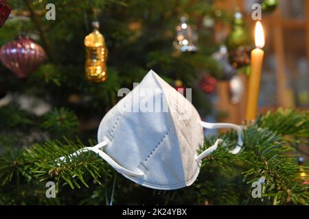 FFP2-Maske hängt auf einem Weihnachtsbaum, Österreich, Europa - FFP2 Maske hängt an einem Weihnachtsbaum, Österreich, Europa Stockfoto