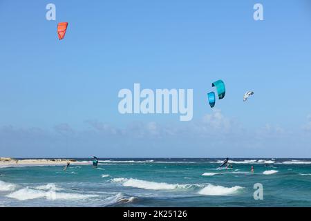 BOCA GRANDI, ARUBA - 17. DEZEMBER 2020: Kite- und Flügelsurfer am Boca Grandi Strand an der südöstlichen Küste der Karibikinsel Aruba in der Nähe Stockfoto