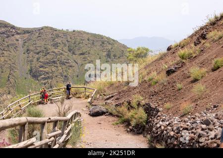 Vesuv, Neapel, Italien - 29. Juli 2021: Touristen, die an einem heißen Tag auf dem Wanderweg zum Vulkan Vesuv wandern. Der Pfad besteht aus sh Stockfoto