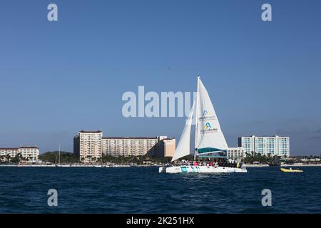 PALM BEACH, ARUBA - 17. OKTOBER 2021: Katamaran-Tour-Boot, das am Palm Beach vor den Marriott- und Radisson Blu-Hotels auf der Karibik i segelt Stockfoto