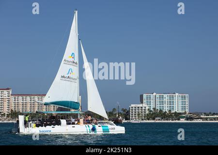 PALM BEACH, ARUBA - 17. OKTOBER 2021: Katamaran-Tour-Boot, das am Palm Beach vor den Marriott- und Radisson Blu-Hotels auf der Karibik i segelt Stockfoto