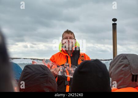 JOKULSARLON, ICELND - 10. MAI 2015: Reiseleiter über die Eisberge auf einer Amphibientour auf dem Gletschersee Jokulsarlon, Island Stockfoto