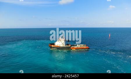 Puerto Plata, DR - 10. Januar 2022: Patrouillenboot segelt in hellblauem Karibikwasser Stockfoto