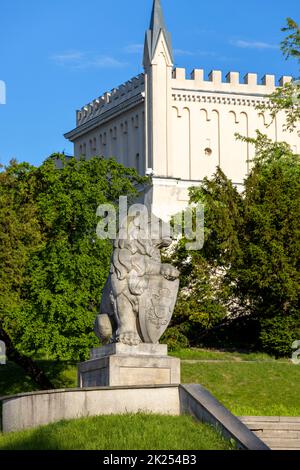 Lublin, Polen - 23. Mai 2022: Lublin Castle, neogotische Fassade und Steinstatue des Löwen.die Figur eines Löwen wurde nach dem Muster nachgebildet Stockfoto
