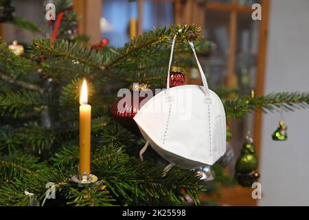 FFP2-Maske hängt auf einem Weihnachtsbaum, Österreich, Europa - FFP2 Maske hängt an einem Weihnachtsbaum, Österreich, Europa Stockfoto