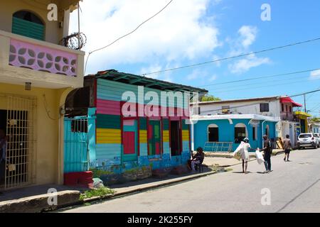 Puerto Plata, DR - 04. Mai 2022: Menschen vor Ort in der Nähe von bunten Gebäuden im Zentrum von Puerto Plata, Dominikanische Republik Stockfoto