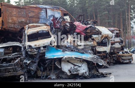 Rostig verbrannte Autos, die durch Raketenexplosionen zerstört wurden. Krieg in der Ukraine. Zerstörte Fahrzeuge von Zivilisten, die abreisten, wurden aus der Kampfzone evakuiert Stockfoto