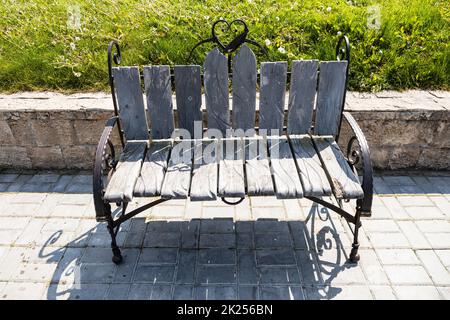 Kolomna, Russland - 10. Juni 2022: Geschmückte, geschmiedete Bank am Ufer des Moskwa Flusses in Kolomna am sonnigen Sommertag. Stockfoto