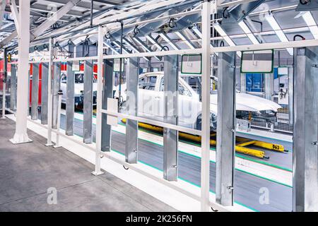 Vorbereitete Autos in einer Reihe im Kontrolltunnel im Automobilwerk Stockfoto