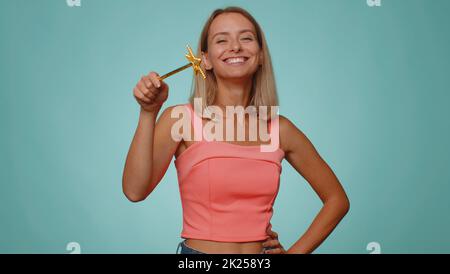 Magier Zauberer Frau gesturing mit Zauberstab Fee Stock, so dass Wunsch wahr, Gießen Zauberspruch, Werbung Urlaub Verkauf Rabatt. Junge Hexe Mädchen isoliert auf blauem Studio-Hintergrund Stockfoto