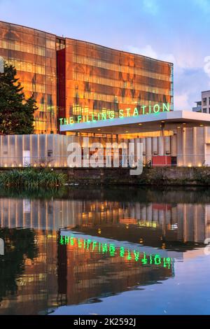 Ein Neonschild an der Tankstelle, einem Restaurant in King's Cross, spiegelt sich im Wasser des Regent-Kanals bei Sonnenuntergang in London, Großbritannien, wider Stockfoto