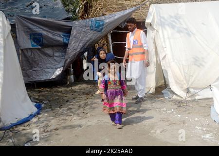 Peshawar, Pakistan. 22. September 2022. Vom Hochwasser betroffene Kinder gehen am 22. September 2022 in Richtung einer provisorischen Schule am Stadtrand von Peshawar, Pakistan. Laut der National Disaster Management Authority (NDMA) wurden in den letzten 24 Stunden in Pakistan mindestens sieben Menschen getötet und zwei weitere verletzt, die durch Monsunregen ausgelöste Sturzfluten verursacht wurden. Quelle: Str/Xinhua/Alamy Live News Stockfoto