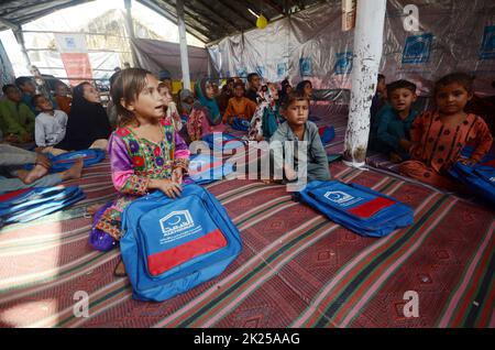 Peshawar, Pakistan. 22. September 2022. Vom Hochwasser betroffene Kinder besuchen am 22. September 2022 eine Klasse an einer provisorischen Schule am Stadtrand von Peshawar, Pakistan. Laut der National Disaster Management Authority (NDMA) wurden in den letzten 24 Stunden in Pakistan mindestens sieben Menschen getötet und zwei weitere verletzt, die durch Monsunregen ausgelöste Sturzfluten verursacht wurden. Quelle: Str/Xinhua/Alamy Live News Stockfoto