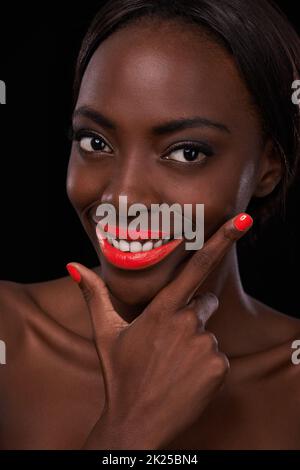 Aufmerksamkeit auf ihr Lächeln lenken. Beschnittene Ansicht einer attraktiven afrikanischen Frau mit leuchtend roten Lippen. Stockfoto