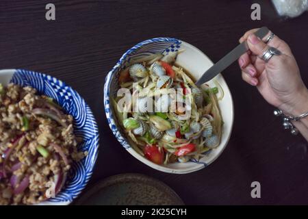 THAILÄNDISCHES ESSEN, würziger Papaya-Salat mit Herzmuschel Stockfoto