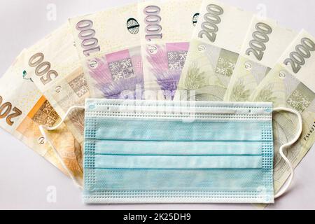 Die Maske wird auf die Banknoten der tschechischen Krone gelegt Stockfoto
