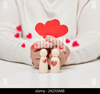 Paar hölzerne Männer der Braut und Bräutigam, rotes Herz, Konzept der Liebe und Beziehungen Stockfoto