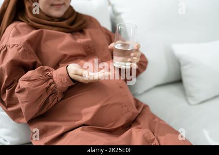 Schwangere Muslime, Die Eine Folsäure-Pille Einnehmen Stockfoto