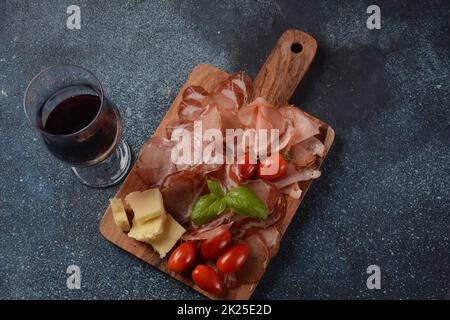 Italienische gehärtete Schweineschulter. Antipasto-Platte coppa stagionata und Kirschtomaten. Traditionelle Wurst in Scheiben mit Gewürzen Stockfoto