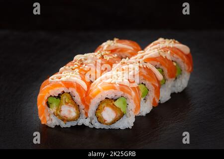 Lebhaftes Sushi-Set, kreatives Ideenkonzept. Sushi-Brötchen aus Kalifornien oder Philadelphia. Konzept der traditionellen japanischen Küche. Mit Sesamsamen bestreut Stockfoto