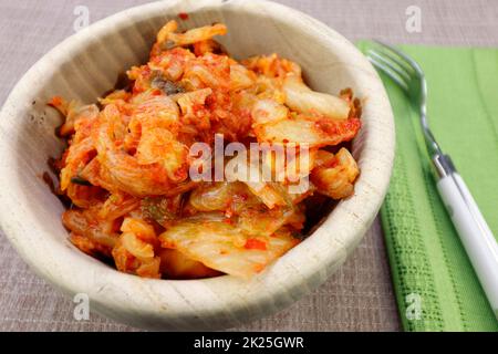 Scharfes Kimchi in einer runden Holzschüssel – Nahaufnahme Stockfoto