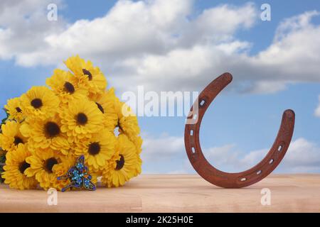 Gelbe Blumen und Schmetterlingsschmuck mit Blue Sky und Hufeisen Stockfoto