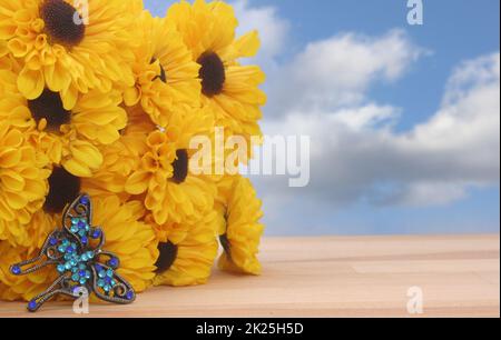 Gelbe Blumen und Schmetterlingsschmuck mit blauem Himmel Stockfoto