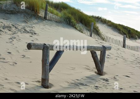 Holztor am Sandstrand vor den Dünen Stockfoto