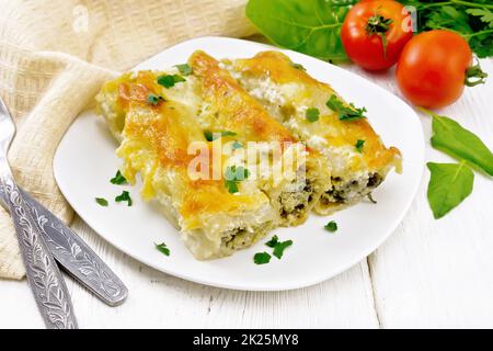 Cannelloni mit Quark und Spinat in Platte auf Lichtplatte Stockfoto