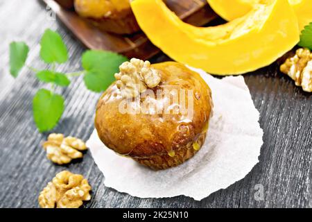 Cupcake-Kürbis mit Orangenglasur und Walnüssen auf Pergament Stockfoto