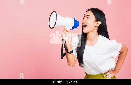 Eine Teenagerin, selbstbewusst lächelndes Gesicht, die eine Ankündigungsbotschaft macht, schreiend in Megafon Stockfoto