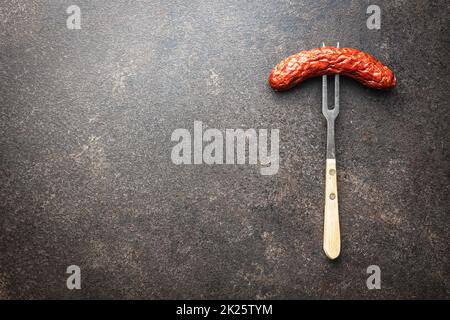 Geräucherte Wurst auf eine Gabel gestochen Stockfoto