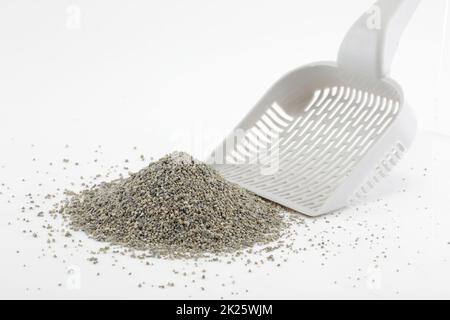 Schaufel und Haufen von Katzenstreu isoliert auf weiß Stockfoto