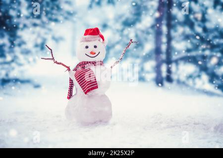Fröhlicher Schneemann mit orangefarbenem Schal und in gelben Stiefeln steht im Winter auf dem Kopf Stockfoto