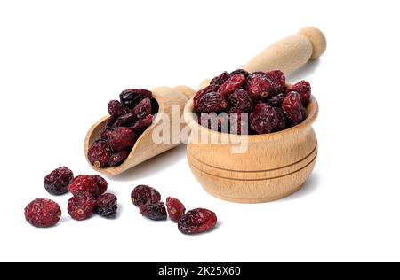 Ein Haufen getrockneter Preiselbeeren in einer Holzschüssel auf weißem Hintergrund. Köstliche Beeren Stockfoto