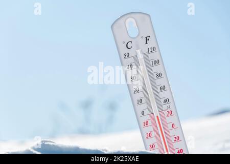 Das Thermometer liegt im Winter auf dem Schnee und zeigt eine niedrige negative Lufttemperatur an. Meteorologische Verhältnisse im rauen Klima in den nördlichen Regionen und in der Umwelt. Klimawandel auf der Erde Stockfoto