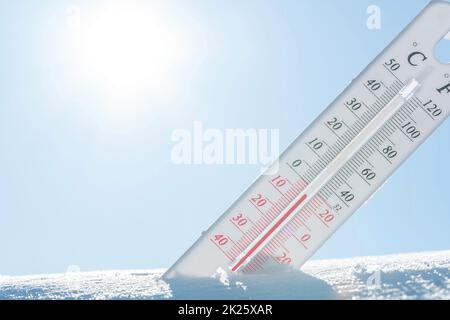 Im Winter oder Frühling liegt das Thermometer auf dem Schnee und zeigt bei kaltem Wetter eine negative Temperatur an.Meteorologische Bedingungen mit niedrigen Luft- und Umgebungstemperaturen.Klimawandel und globale Erwärmung Stockfoto