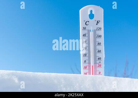 Das Thermometer liegt im Winter auf dem Schnee und zeigt eine niedrige negative Lufttemperatur an. Meteorologische Verhältnisse im rauen Klima in den nördlichen Regionen und in der Umwelt. Klimawandel auf der Erde Stockfoto